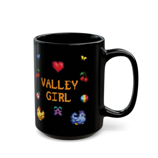 A black ceramic mug displays pixel art graphics from Stardew Valley including chickens, cherries, a prismatic stardrop, and the words "Valley Girl.