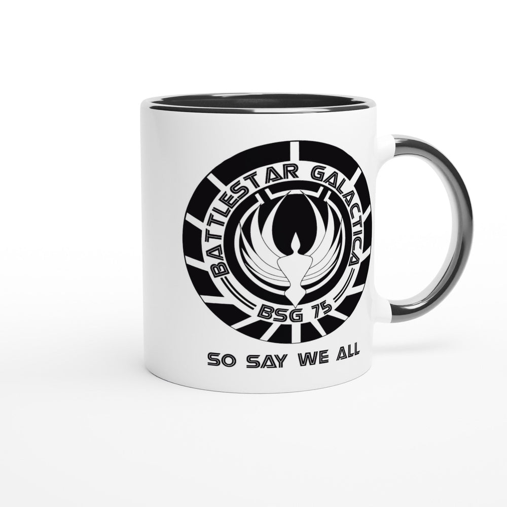 A white ceramic mug features a black rim and handle, displaying the Battlestar Galactica logo with "BSG 75" and "So Say We All" printed around it.