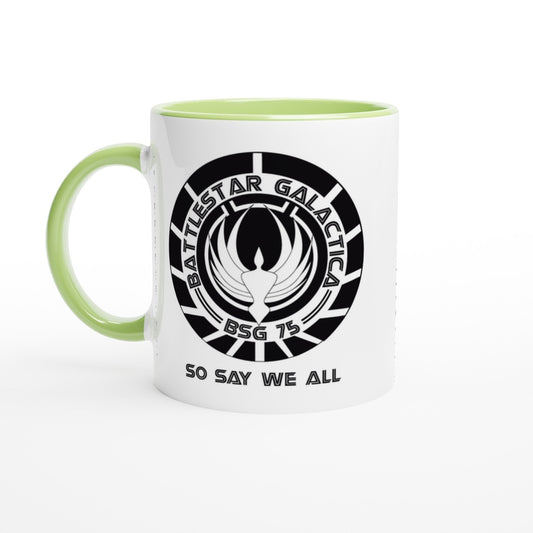 A white mug features a circular design displaying the Battlestar Galactica logo and the phrase "So Say We All" along with "BSG 75".