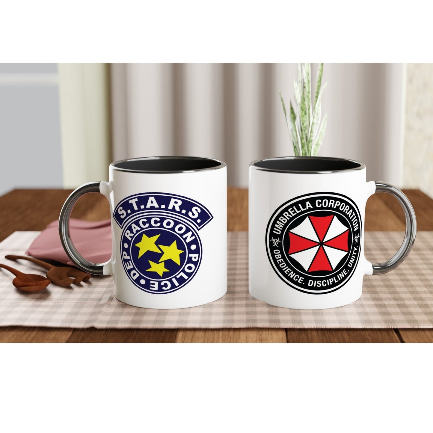 Two mugs with Resident Evil logos on a table with a checkered tablecloth