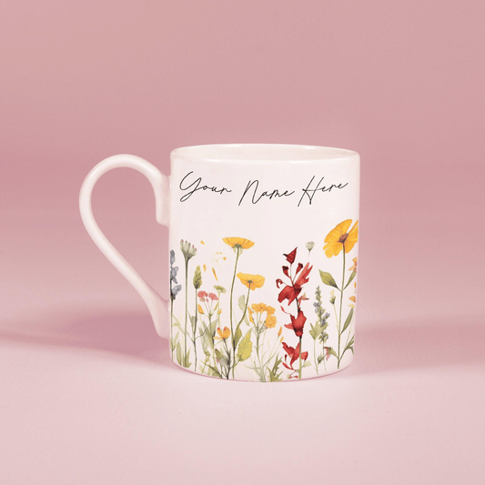 A white china mug features a watercolour floral design of wildflowers and personalized text reading "Your Name Here".