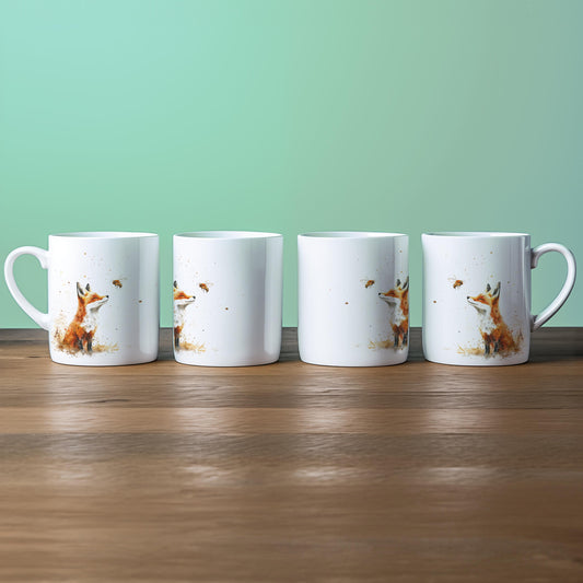 Four white china mugs display a watercolour illustration of a fox alongside a bee.