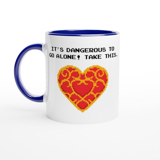 A white mug with a blue handle and rim features pixel art of a Zelda Heart Container and the words "It's dangerous to go alone! Take this.