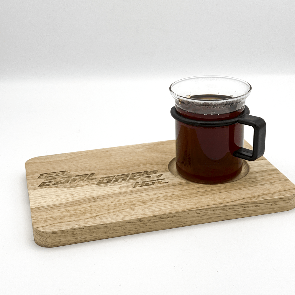 A wooden chopping board labeled "Tea, Earl Grey, Hot" holds a glass mug filled with dark tea.