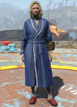 A person wearing a blue Fallout embroidered logo bathrobe stands against a backdrop of a post-apocalyptic landscape.