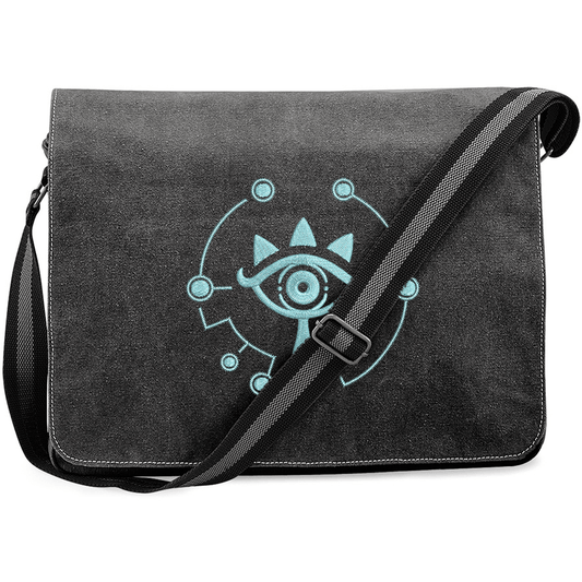 A black Zelda Sheikah Messenger Bag features glow-in-the-dark embroidery of a stylized eye symbol on the front flap.