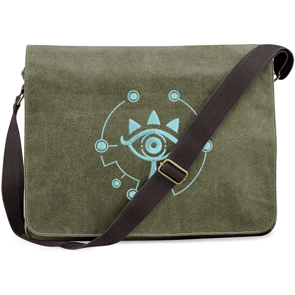 This Zelda Sheikah Messenger Bag features a light blue embroidered design of the Sheikah eye symbol on an olive green background.