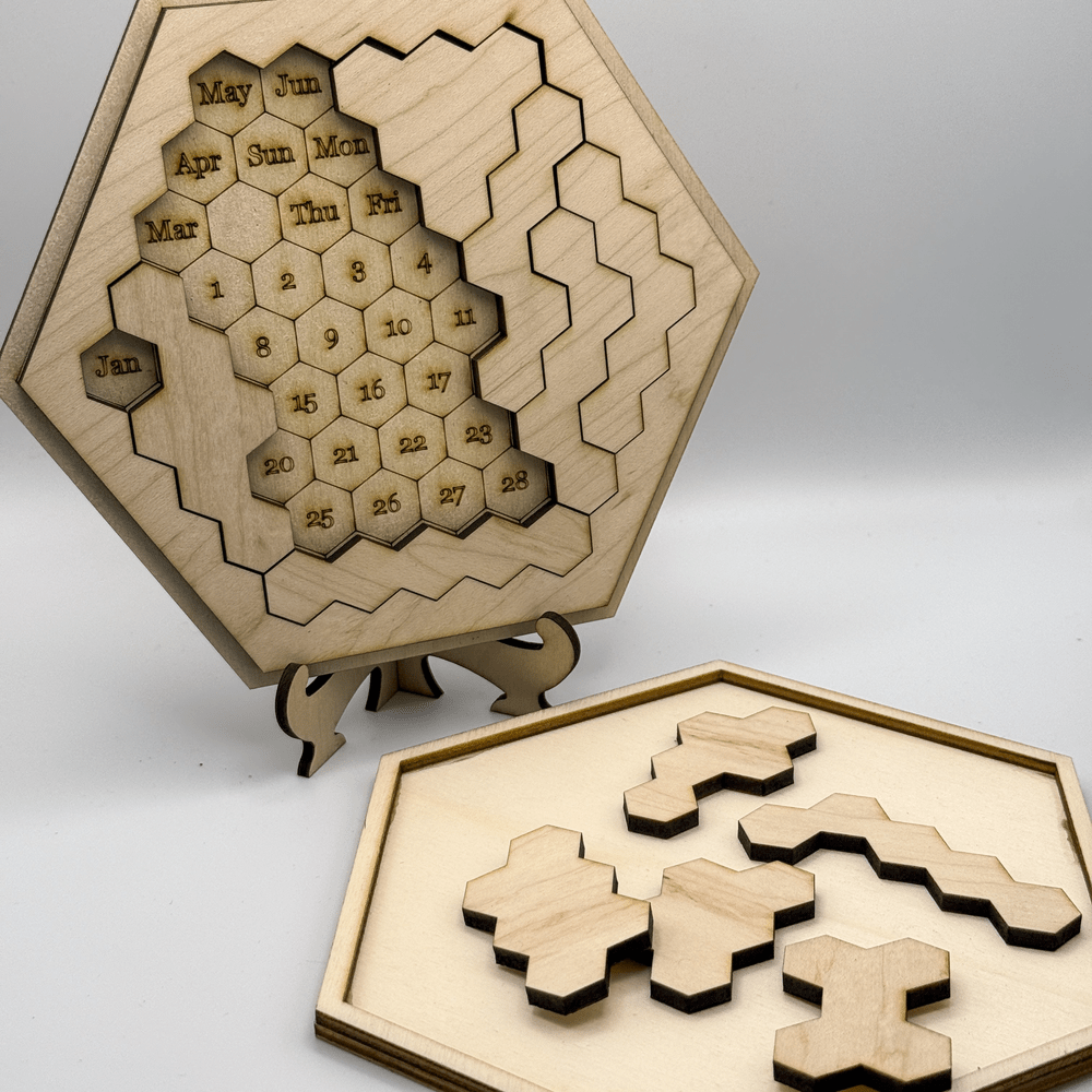 A wooden Hexagon Calendar Puzzle displays month and date tiles arranged in a hexagonal pattern on a stand alongside loose hexomino pieces.