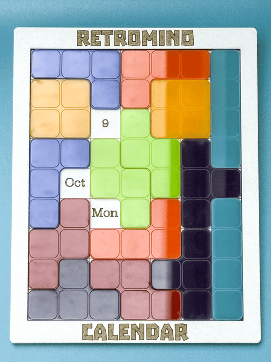 A KronoBlox puzzle calendar displays the date as October 9th, Monday, arranged in a Tetromino pattern reminiscent of retro video games.