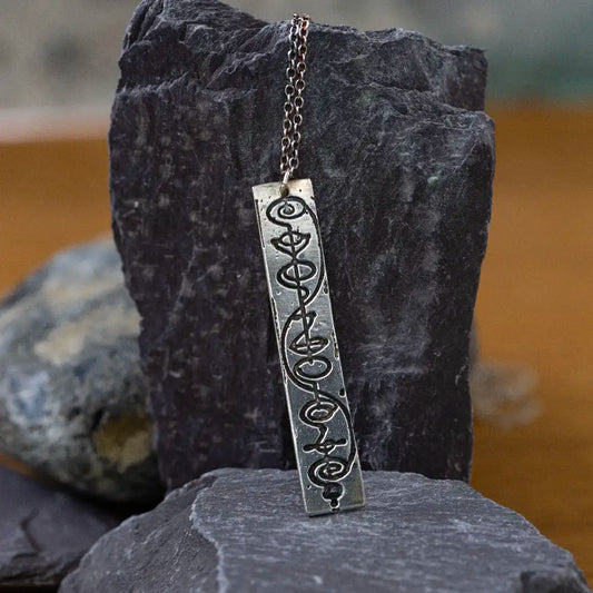 Vulcan IDIC sterling silver necklace against a rock, Star Trek inspired jewellery for Trekkies