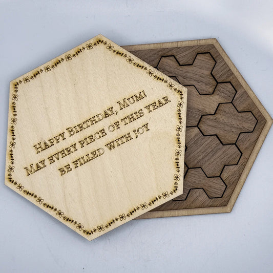 A wooden hexagon calendar puzzle features a central tile inscribed with "Happy Birthday, Mum! May every piece of this year be filled with joy.