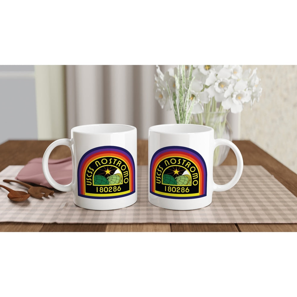 Two white ceramic mugs display a rainbow-colored USCSS Nostromo logo and number 180286.