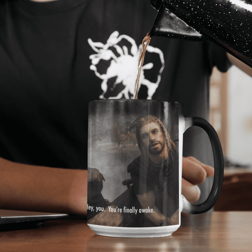 A black Skyrim mug displays a heat-activated image of a character from The Elder Scrolls and the words "Hey You, You're Finally Awake.