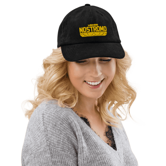 A person wearing a black Alien USCSS Nostromo embroidered hat with a Wings Style logo on the front.