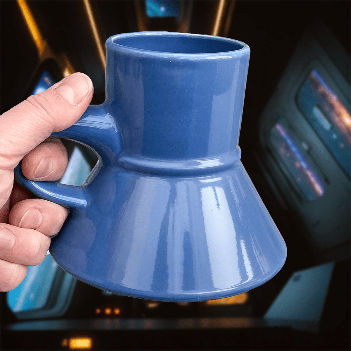A hand holds a blue Replimat mug, referencing Star Trek: Deep Space Nine and Klingon Raktajino.