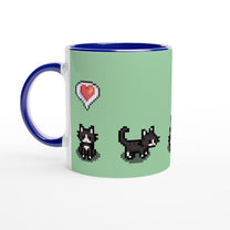A white mug features a light green background with pixelated graphics of tuxedo cats and a heart icon referencing the Stardew Valley game.