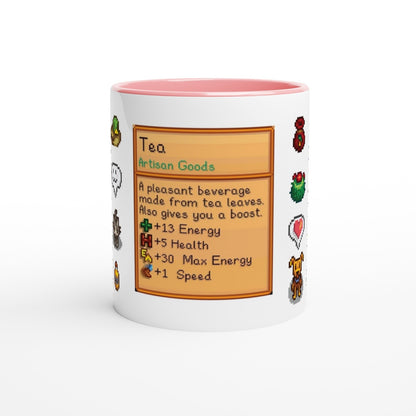 A white mug with a pink rim displays a Stardew Drinks pattern resembling an item card describing tea and its benefits.