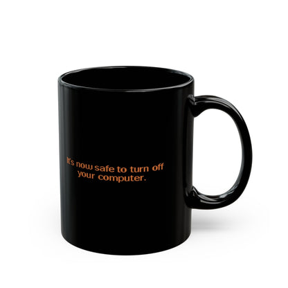 A black mug displays the text "It's now safe to turn off your computer," referencing a nostalgic Windows 95/98 message.