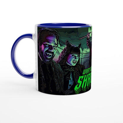 A ceramic mug displays an illustration of Laszlo and Nadja from What We Do In The Shadows, along with a partial view of the show's title.