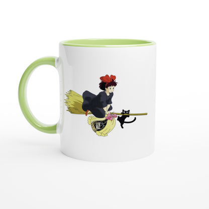 A white mug depicts Kiki from Kiki's Delivery Service riding a flying broomstick with her cat Gigi, inspired by Studio Ghibli.