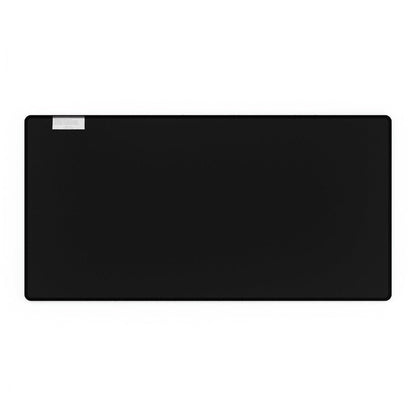 A rectangular black desk mat featuring a small white label in the upper left corner.
