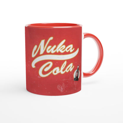 A red mug features a vintage distressed poster design displaying the "Nuka Cola" logo and an illustration of a bottle, referencing the Fallout video game series.