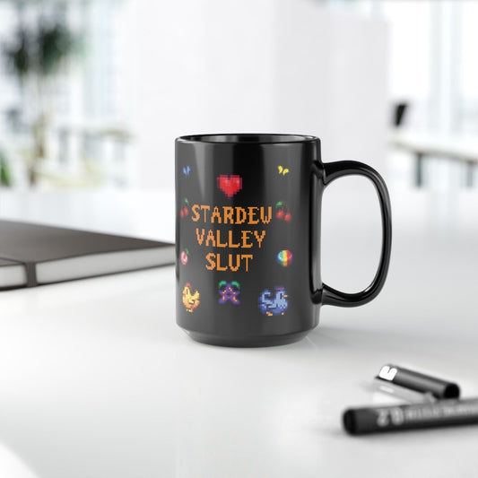 A black mug featuring pixel art graphics and the text Stardew Valley Slut in a colorful font.