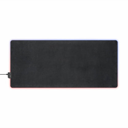 A rectangular black desk mat with pink and blue LED lighting around the edges is shown against a white background.