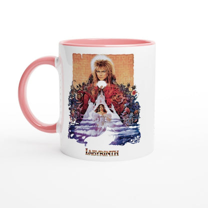 A white mug with a pink handle features an illustration from the 1986 fantasy movie Labyrinth depicting David Bowie as Jareth and Sarah in a maze-like setting, with "Labyrinth" printed at the bottom.