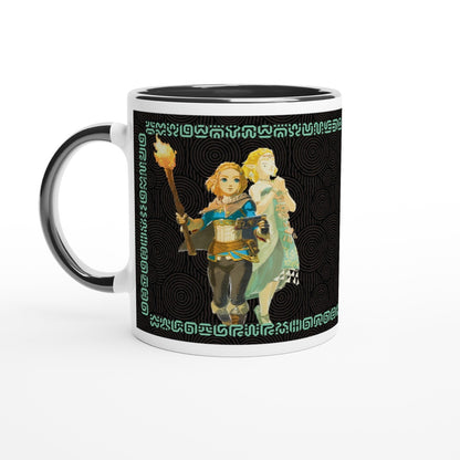 A black mug displays an illustration of Link and Zelda from The Legend of Zelda: Tears of the Kingdom, surrounded by Sheikah script patterns.