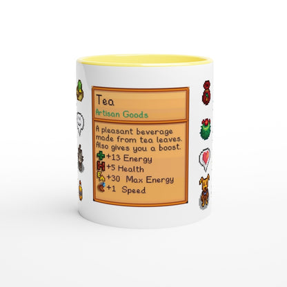 A white mug displays a Stardew Drinks pattern featuring pixelated sprites and a card describing tea as an artisan good with stat boosts for energy, health, and speed.