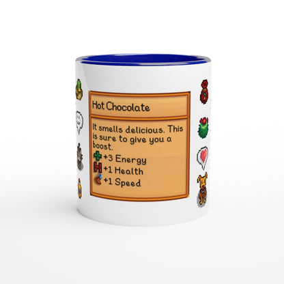 A white mug with a blue rim features a Stardew Drinks pattern including sprites and a beverage card describing hot chocolate.