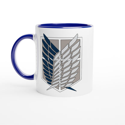 A white ceramic mug with a blue handle and rim displays the Wings of Freedom emblem from Attack on Titan.