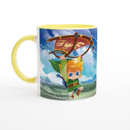 A yellow mug displays a chibi Link from The Legend of Zelda: Tears of the Kingdom soaring through a Hyrule landscape on a paraglider.
