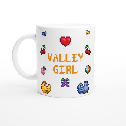 A white coffee mug displays "VALLEY GIRL" in pixelated font surrounded by Stardew Valley sprites and icons including chickens, cherries, a prismatic stardrop, and a heart.
