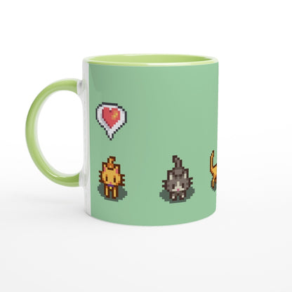 A white mug displays pixel art graphics from Stardew Valley featuring a ginger tabby cat, a gray tabby cat, and a heart emote.