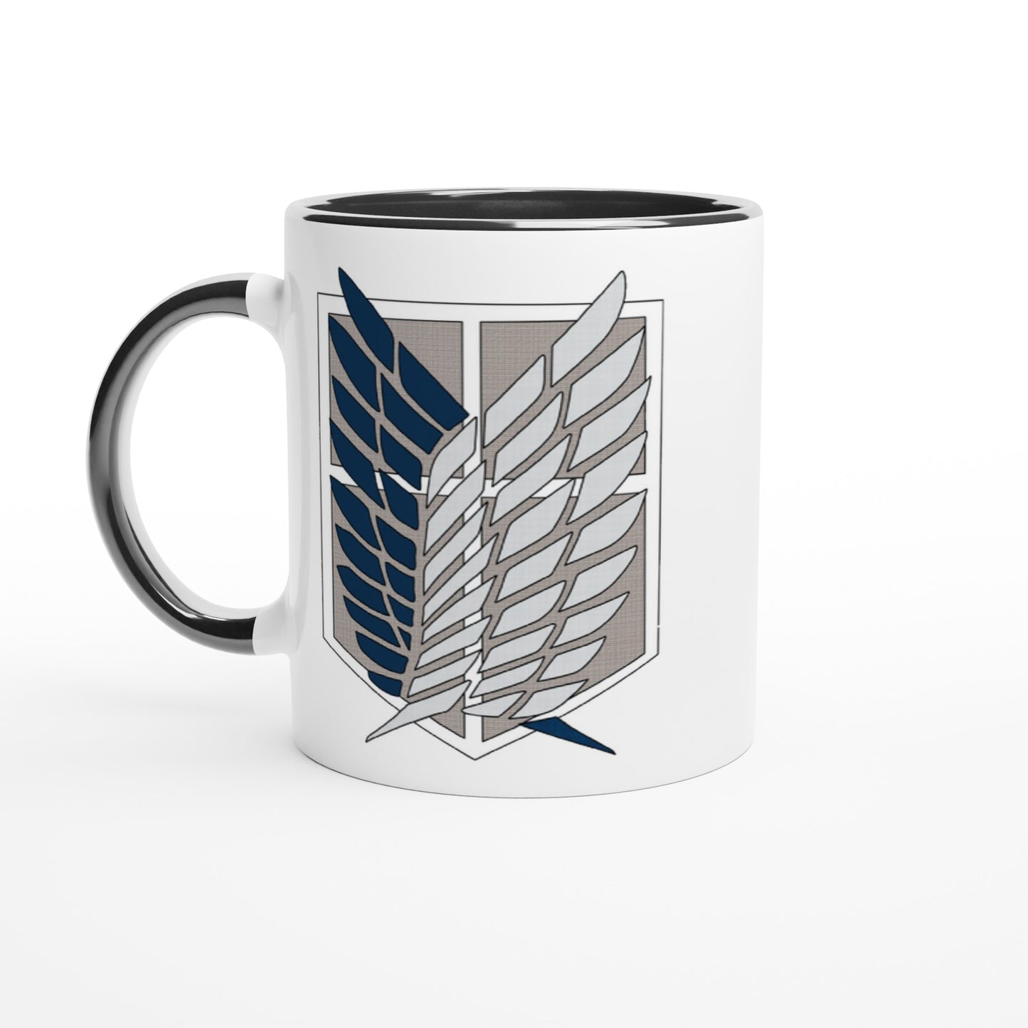 A white ceramic mug displays the Wings of Freedom emblem from Attack on Titan.