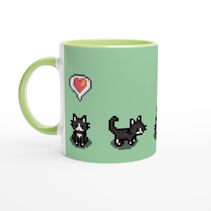 A white mug features pixelated graphics of tuxedo cats and a heart, referencing the Stardew Valley computer game.