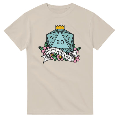A beige t-shirt displays a D20 die surrounded by flowers and a banner reading "That's How I Roll," referencing the tabletop game Dungeons & Dragons.