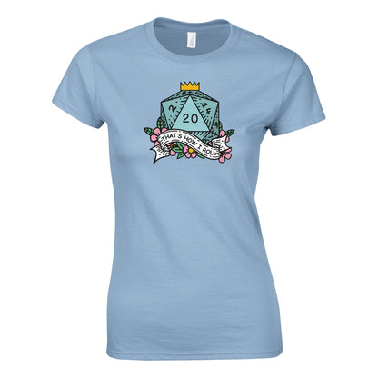 A light blue fitted t-shirt displays a D20 die graphic with a banner reading "That's How I Roll" surrounded by floral details, referencing the D&D game.