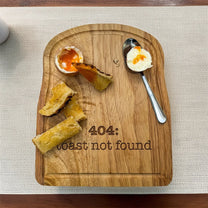 A rubberwood breakfast board featuring the text 404: Toast Not Found, accompanied by a soft-boiled egg and pieces of toast soldiers.
