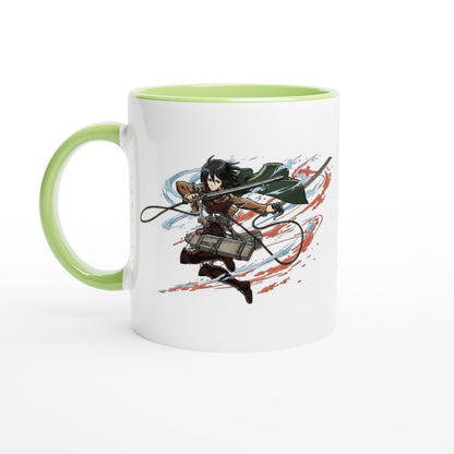 A white ceramic mug displays an illustration of Mikasa Ackerman from the Attack on Titan anime series wielding blades against a red and blue background.