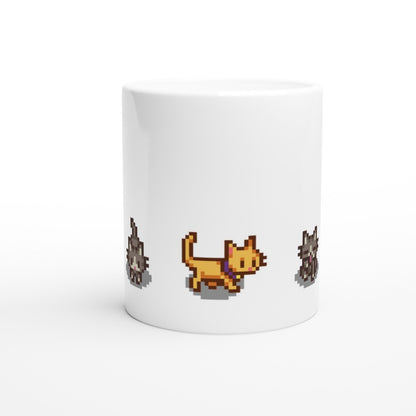 A white mug displays pixelated graphics of ginger and tabby cats, referencing characters from the Stardew Valley computer game.