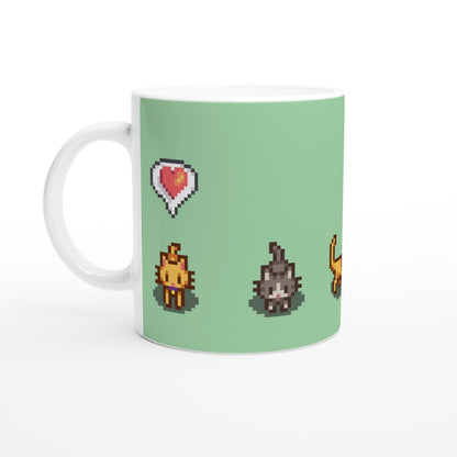 A white mug displays pixel art from Stardew Valley featuring a ginger cat, a tabby cat, and a heart emote on a light green background.