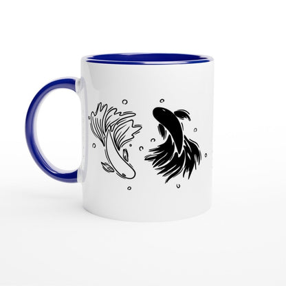 A white mug with a blue handle and rim features a black and white illustration of two betta fish arranged in a yin yang design.