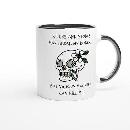A white ceramic mug with a black rim features a drawing of a skull adorned with flowers and the phrase "Sticks and Stones May Break My Bones... But Vicious Mockery Can Kill Me!