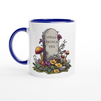 A white ceramic mug with a blue handle and rim features an illustration of a tombstone surrounded by flowers and mushrooms that reads "Dead People Tea.