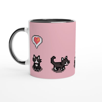 A white mug displays pixelated graphics from Stardew Valley featuring two tuxedo cats and a heart emote on a pink background.
