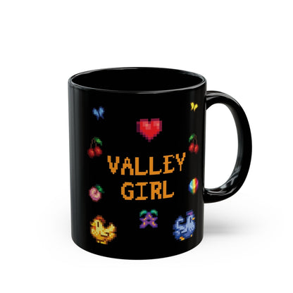 A black coffee mug displays pixel art sprites / graphics from Stardew Valley including a heart, cherries, a prismatic shard, a stardrop, and butterflies.