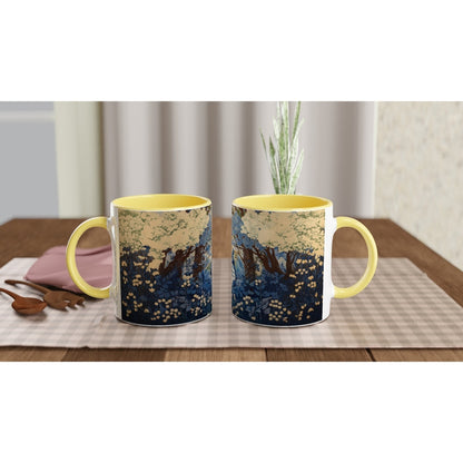 A yellow mug displays a Studio Ghibli-inspired design depicting a cherry blossom forest scene in a chinoiserie style.
